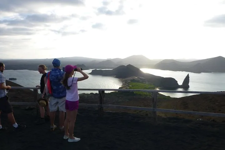 Turistas disfrutando de las vistas panorámicas de la Isla Bartolomé y la Roca Pinnacle al atardecer.